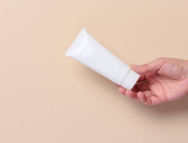 istock A woman's hand holds a white plastic tube for cream, toothpaste on a beige background 1744748180