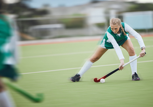 Hockey, athlete and woman running in game, tournament or competition with ball, stick and action on artificial grass. Sports, training and women play in exercise, workout or motion on the ground