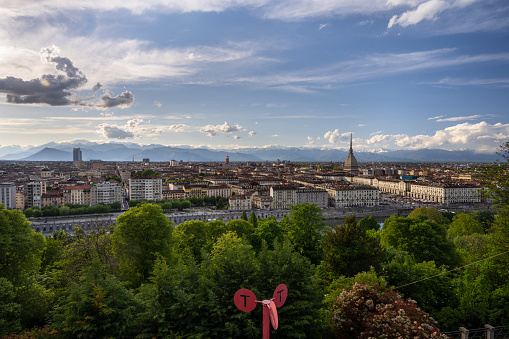 Wide view from the Monte dei Cappuccini of Turin with Mole Antonelliana and mountains in the background, the Po river in front.