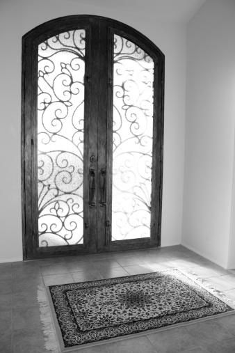 Ornate door with rug in foyer.