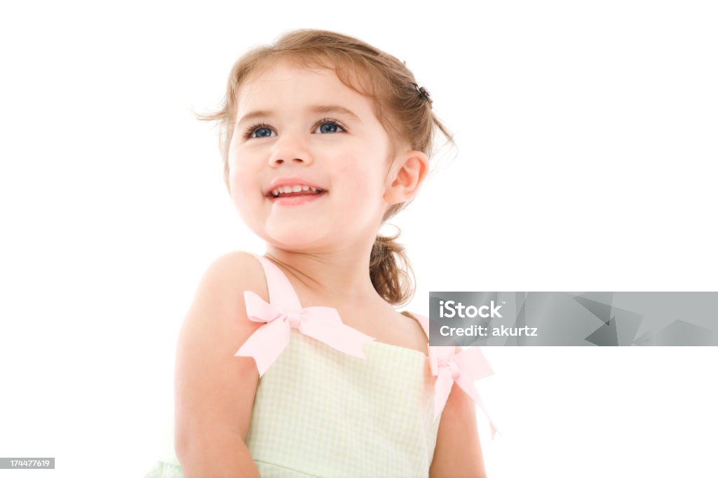 Bright eyed beautiful little happy girl smiling blissfully isolated portrait Bright eyed beautiful little girl in a light green and white checkered dress with pretty pink bows. Blue Eyes Stock Photo