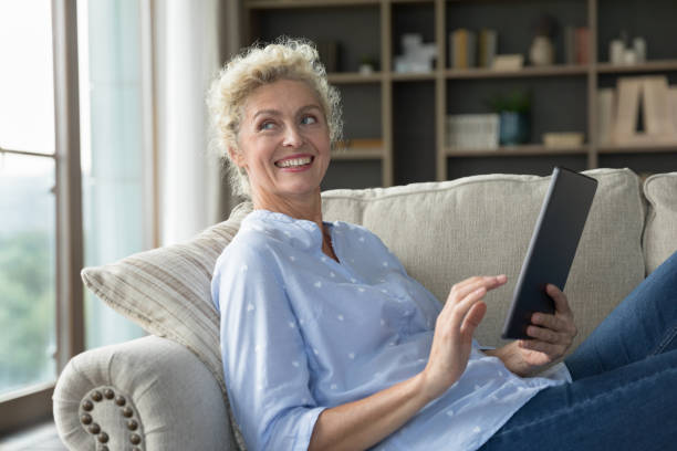 istock Happy beautiful middle aged woman holding tablet computer 1744783411
