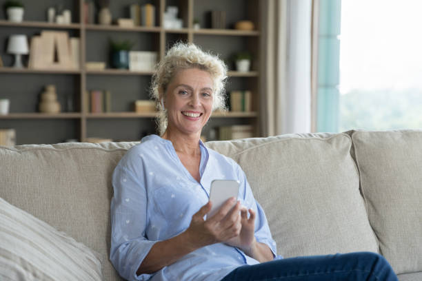 istock Positive beautiful blonde mature woman using mobile phone 1744783447