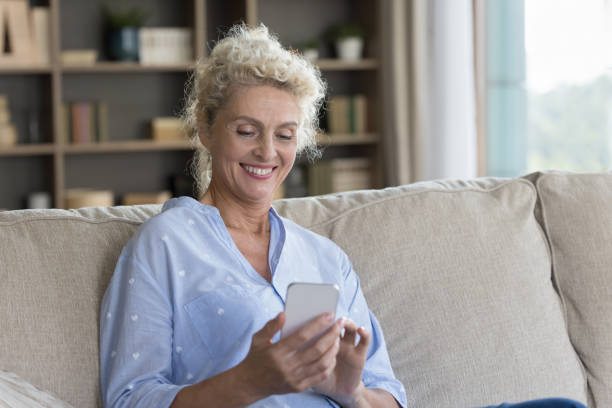 istock Happy senior mature woman using online application at home 1744783724