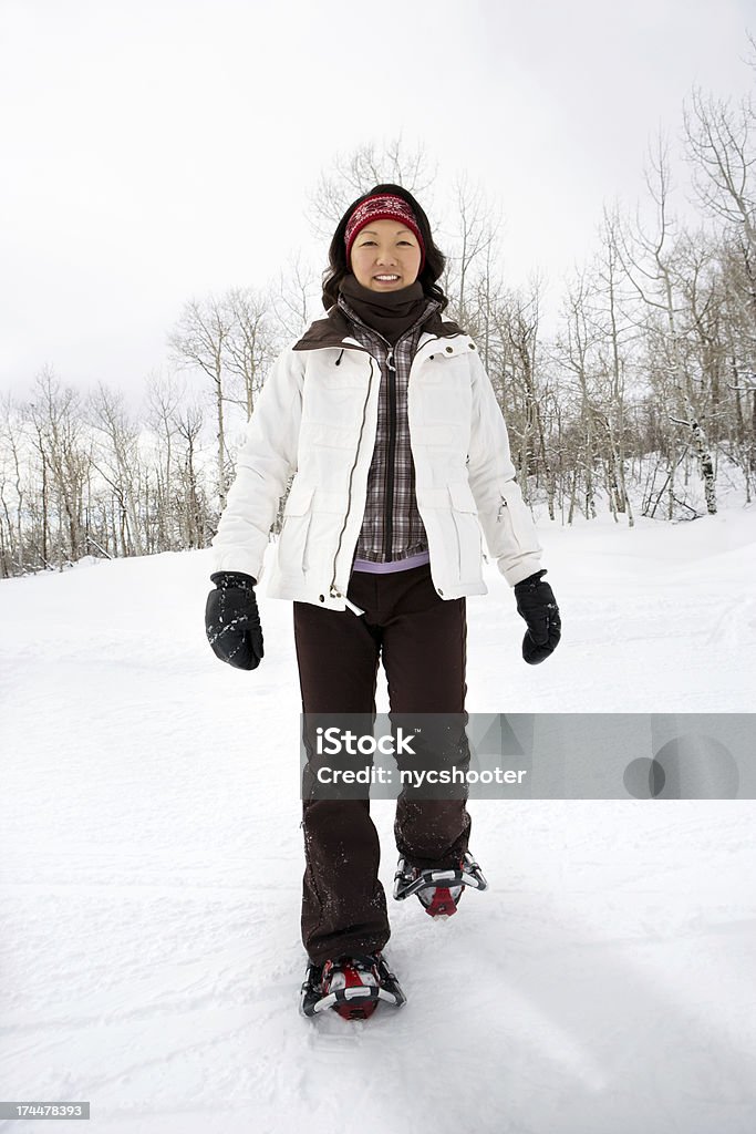Giovane donna con le racchette da neve - Foto stock royalty-free di Escursionismo