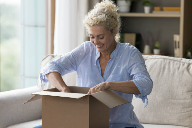istock Cheerful excited customer woman getting parcel, opening cardboard box 1744783996