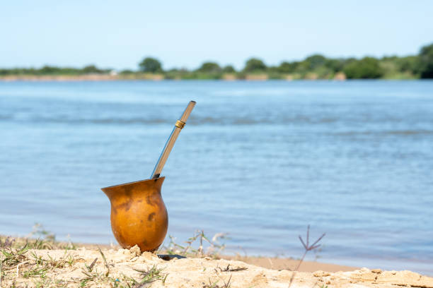 мате отдыхает на песке на берегу реки. - argentina buenos aires yerba mate gaucho стоковые фото и изображения