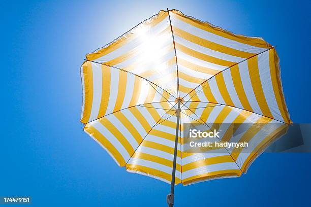 Foto de Guardasóis Amarelos Contra O Sol E Céu Azul e mais fotos de stock de Guarda-chuva - Guarda-chuva, Guarda-sol, Praia