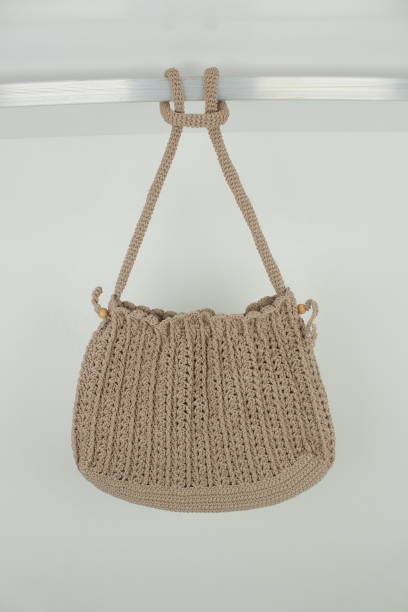 istock Knitted handmade milky brown bag isolated on white background. Close up. 1744791676