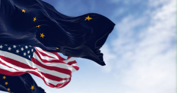 istock American and Alaskan flags wave in the wind against a blue sky 1744792381