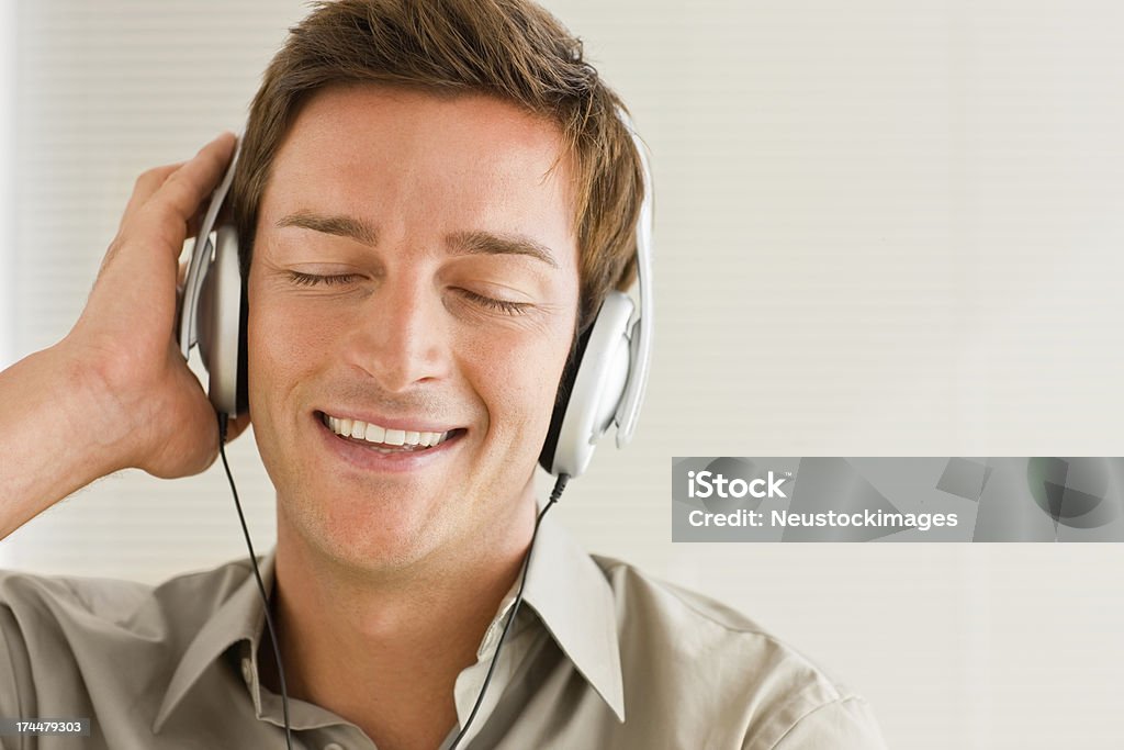 Felice giovane uomo ascoltando musica - Foto stock royalty-free di 25-29 anni