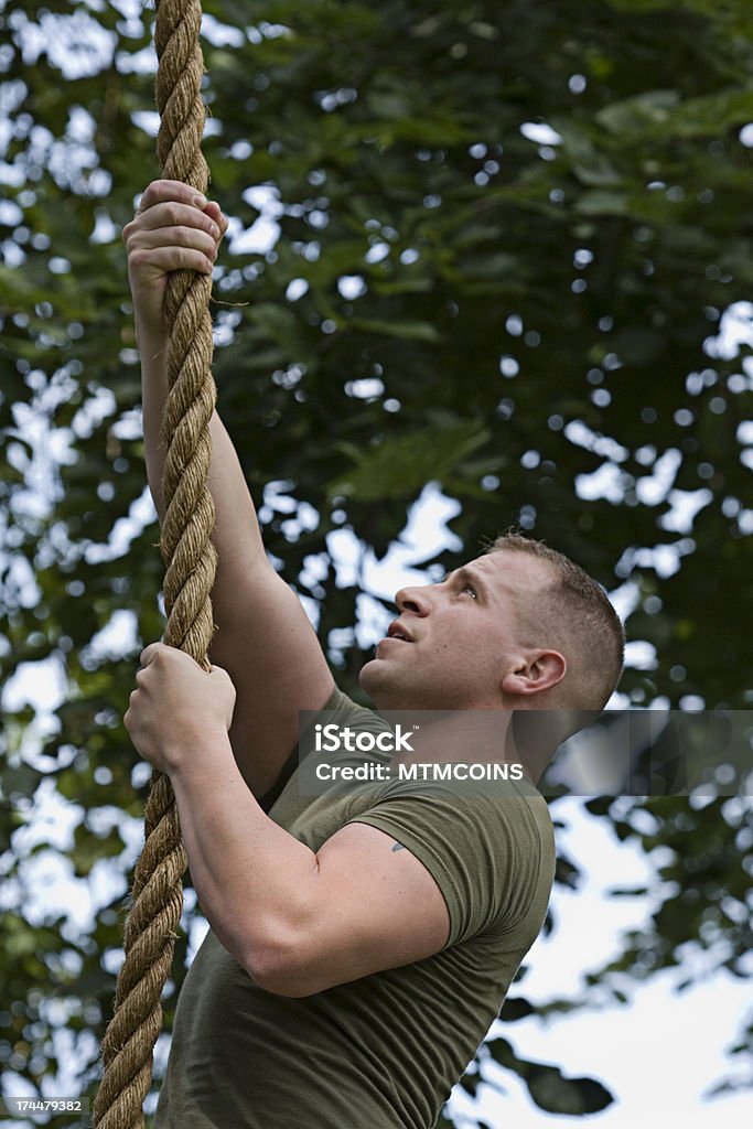 Marine in Training Climbing Rope Marine climbing a rope. Exercising Stock Photo