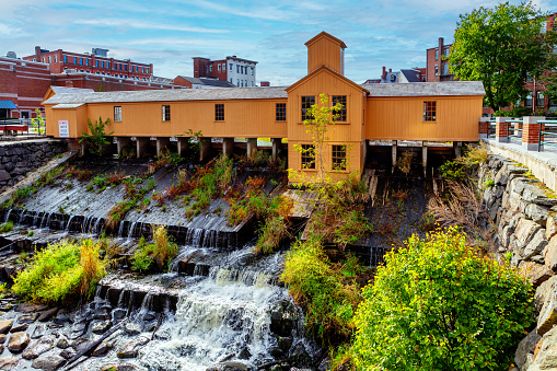 Lowell, Massachusetts, USA - October 15, 2023:  The original layout of the Pawtucket Canal Lower Locks and Dam was constructed 1822-23. However, the current facilities are from a 1841-43 rebuild of the dam and narrowing of the locks. The Pawtucket Canal Lower Locks and Dam are part of the Lowell Power Canal System, the largest power canal system in the United States. Lowell was Incorporated in 1826 to serve as a mill town, it was named after Francis Cabot Lowell, a local figure in the Industrial Revolution. The city became known as the cradle of the American Industrial Revolution because of its textile mills and factories. Many of Lowell's historic manufacturing sites were later preserved by the National Park Service to create Lowell National Historical Park.