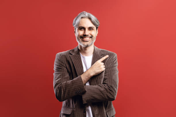 istock man in striped blazer smiling, pointing to the side 1744804945