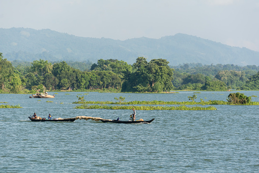Beneath Blue Skies: A serene moment of fishing in Kaptai Lake, a source of livelihood in Rangamati, Bangladesh