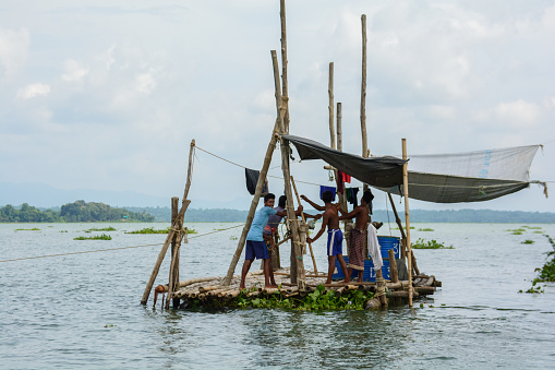 A fisherman's hard work is evident as he casts his net in the heart of Kaptai Lake