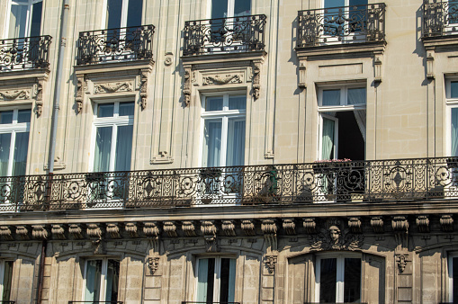 Detail of modern apartment building with balconies decorated with potted plants.