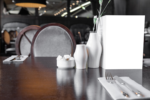 Served table in restaurant with empty mockup menu for advertising text and design