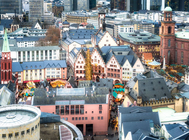 A high angle view over Frankfurt's Christmas markets, tall Christmas tree, and fairground rides, photographed in December.