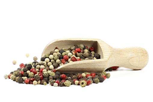 wooden scoop with mixed peppercorns isolated on white background