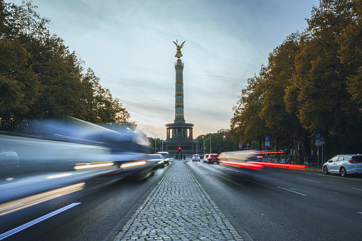 long exposure of rush hour traffic in front of Berlin victory column at sunset in autumn