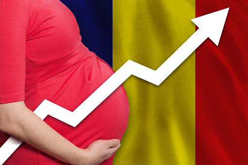 Pregnant woman close up on flag of Romania background. Birth rate up