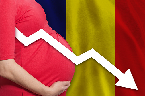 Romanian pregnant woman on flag of Romania background. Falling fertility rate