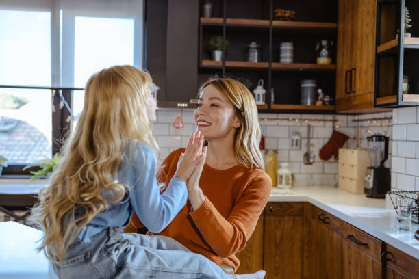 istock Mother and daughter clapping hands at home 1744848334