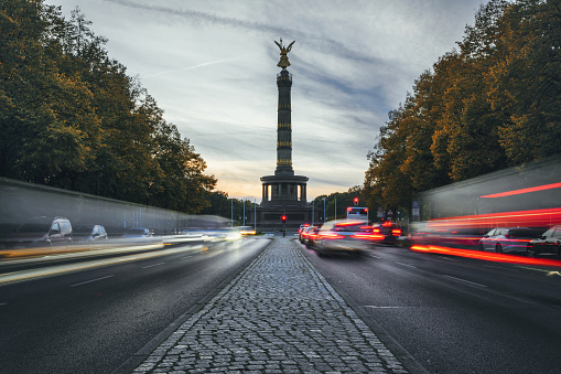 long exposure of rush hour traffic in front of Berlin victory column at sunset in autumn