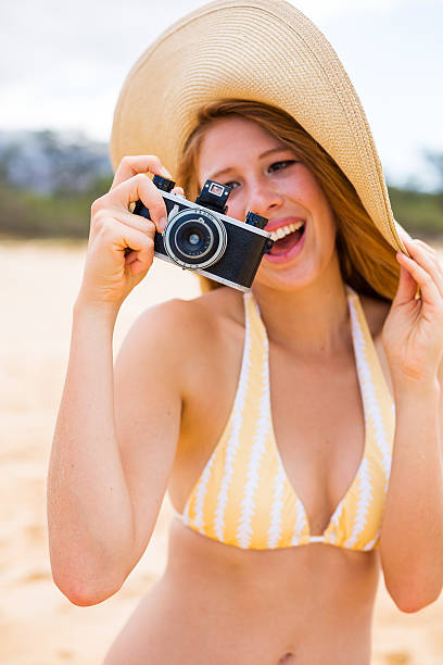 istock Beautiful Woman at the Beach with Camera 174485913