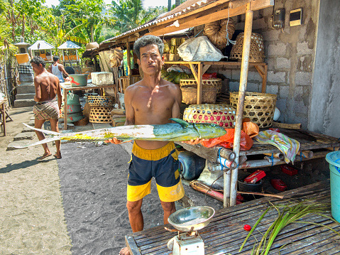 Amed, Indonesia - August 16, 2015: proud fisherman presents his catch of the day at his beach hut.