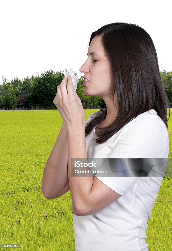 Woman Blowing Her Nose A beautiful woman with a cold, hay fever or allergies blowing her nose Adult Stock Photo