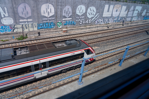 Inter city train with graffiti , in train station.