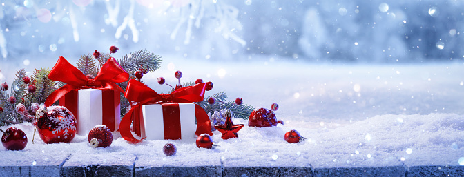 Christmas Gifts With Red Bows On A Background Of A Beautiful Snowy Winter Forest