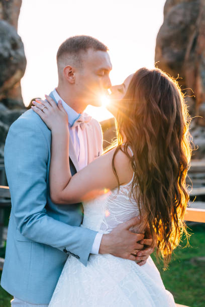 istock Wedding couple kissing and hugging on rocks at sunset 1744891750