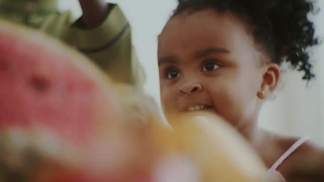 Happy child eats fruit