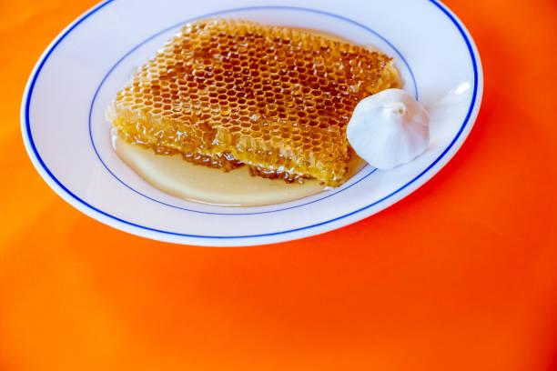 istock Hoeny with garlic on orange background 1744895907