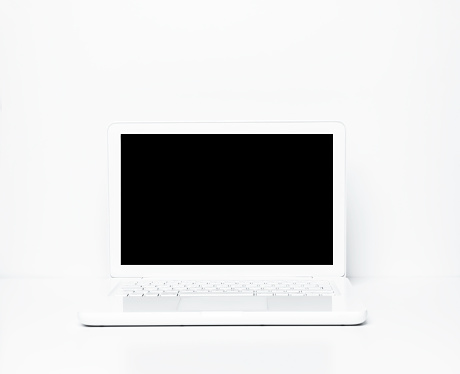 White laptop on the white office desk.