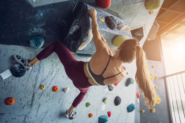 istock A strong female climber climbs an artificial wall with colorful grips and ropes. 1744899578