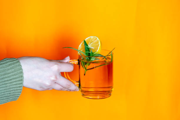 istock hands holding glass cup with orange background 1744901769