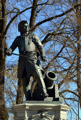 Oslo, Norway: statue of Admiral Peter Wessel Tordenskiold of the Royal Dano-Norwegian Navy, bearing a sword and near a naval gun - sculpted by Axel Elder in 1901, trees in the background, Rådhusplassen.