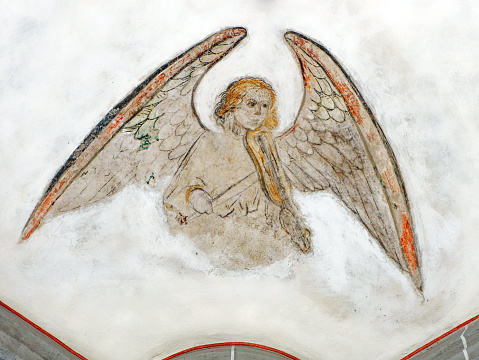 old fresco of an angel with violin, unfinished restored