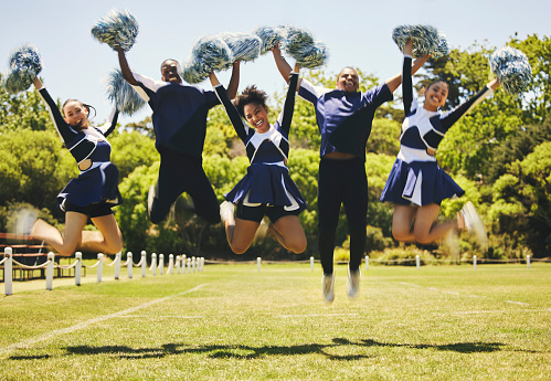 Cheerleader team portrait, smile and jump for performance on field outdoor in training, celebration or exercise. Happy, cheerleading group and energy for support at event, sport competition and blur