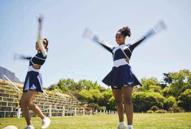High school cheerleader performing routine at football game