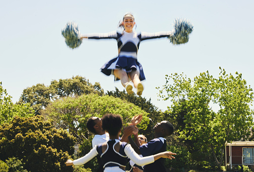 Cheerleader, sky stunt and sports performance on field with teamwork, trust and collaboration. Team, training and prepare for national competition with gymnastics, energy and skill with excellence
