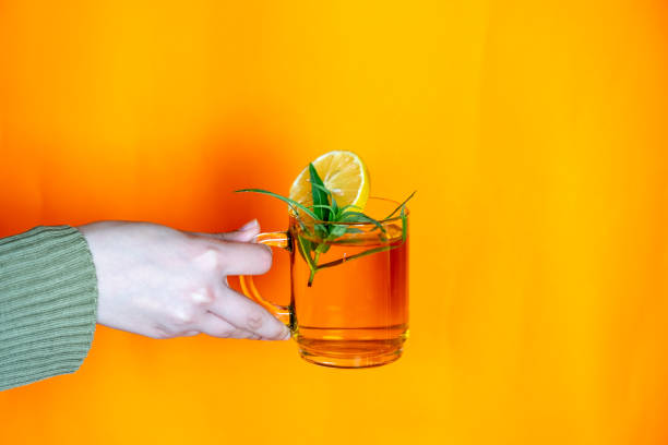 istock hands holding glass cup with orange background 1744945693