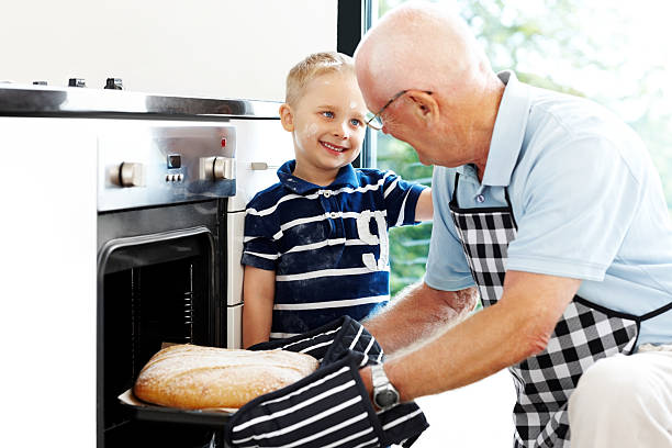 Smiling Asian mother teaching daughter child girl preparing and kneading the dough for baking homemade bakery baguette bread in kitchen together. Kid learning Homeschool Concept