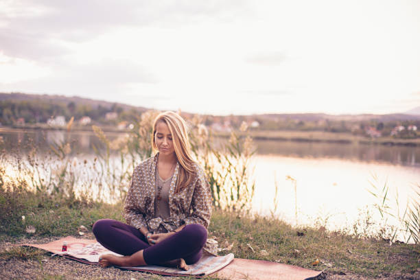 istock Woman meditating by the lake 1744950692