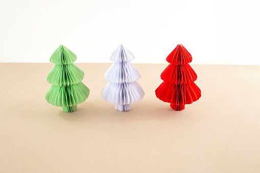 a paper symmetrical shape Christmas tree craft sitting on top of a table, paper texture