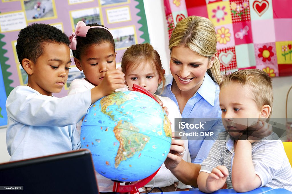 Young teacher explaining the world to preschoolers Kindergarten activities - Young teacher explaining the world to preschoolers Globe - Navigational Equipment Stock Photo